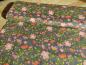 Preview: Patchworkstoff, Meterware in grau mit vielen unterschiedlich großen Blüten in rot und rosa.