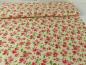 Preview: Patchworkstoff, Meterware. Viele Blumen in rosa und rot auf cremefarbenem Hintergrund.