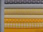 Preview: Verschiedene Baumwollstoffe in grau und gelb.
