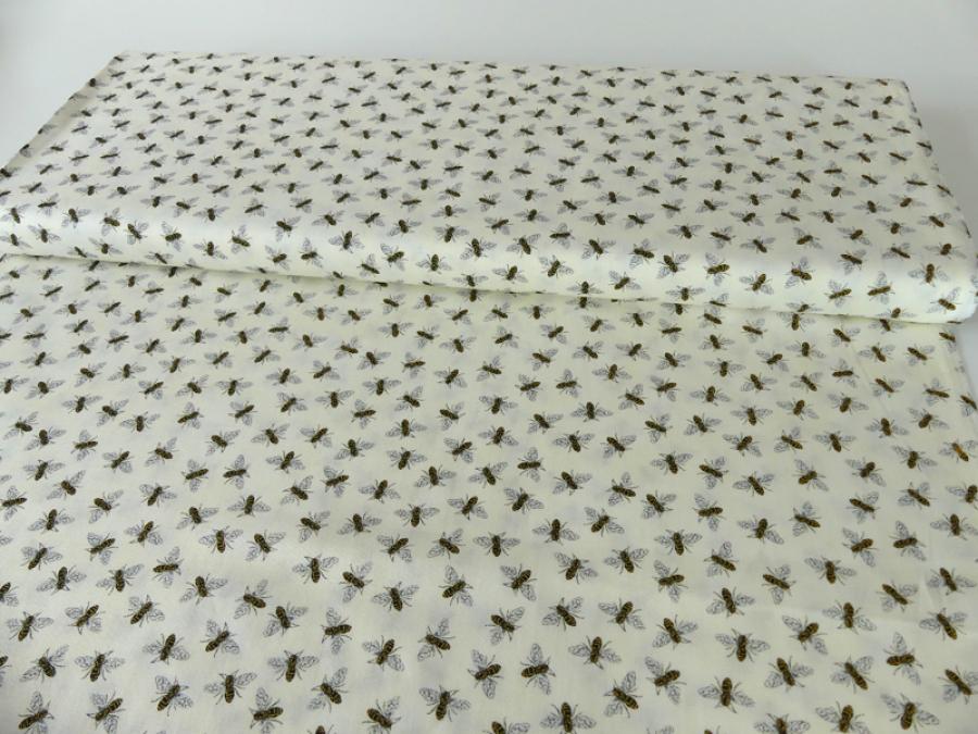 Preview: Stoff für Patchwork in der Farbe creme mit kleinen schwarzen Bienen.