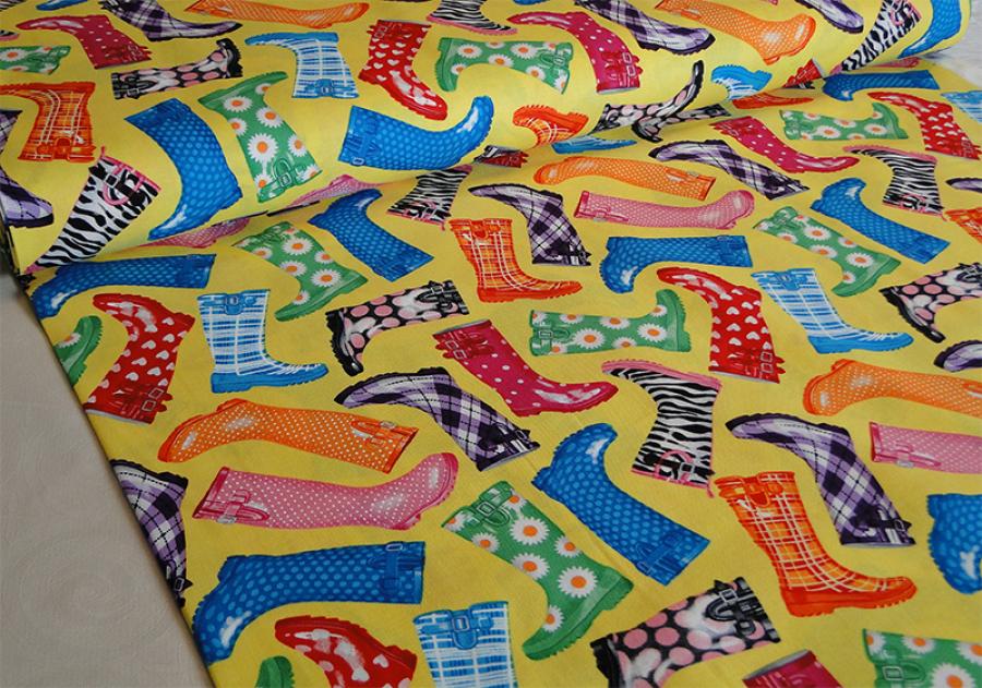 Patchworkstoff mit vielen lustig bunten Gummistifeln auf gelb.. Von Timeless Treasures.
