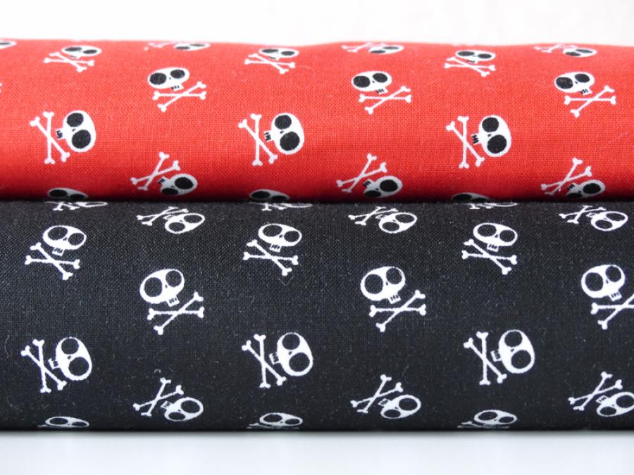 Preview: Patchworkstoff mit Totenköpfen in rot und schwarz.