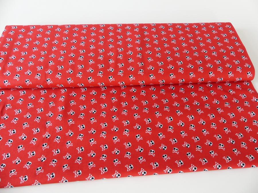 Patchworkstoff in rot mit vielen, kleinen, weißen Totenköpfen von Riley Blake.