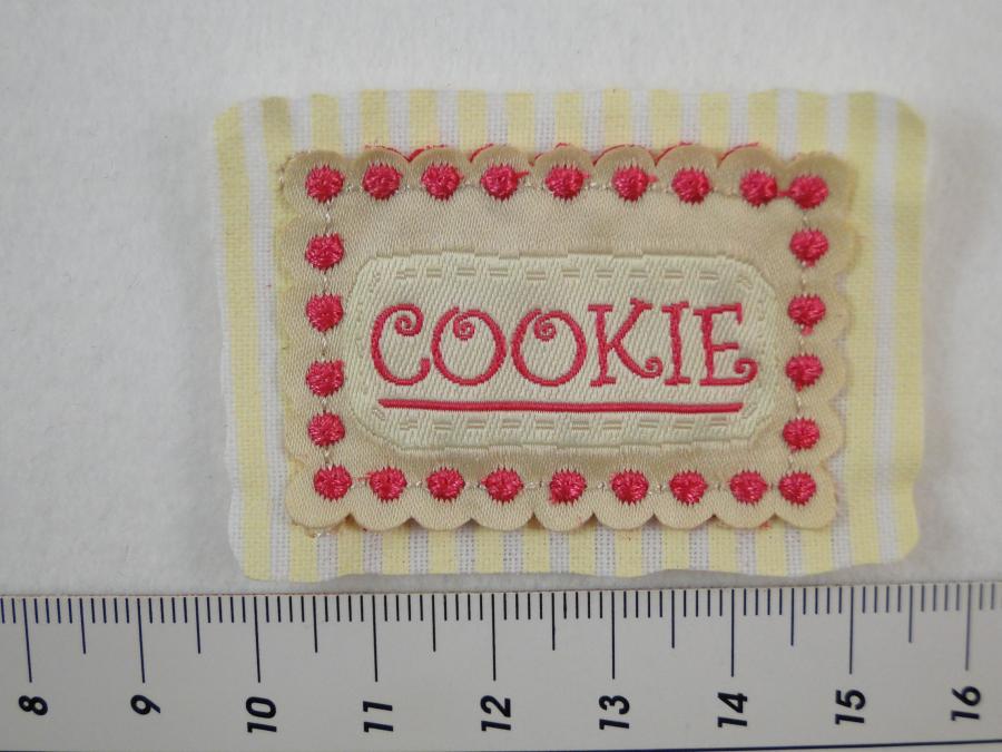 Preview: Etikett zum Aufnähen mit dem Wort Cookie in beige und pink. Detailansicht mit Maß.