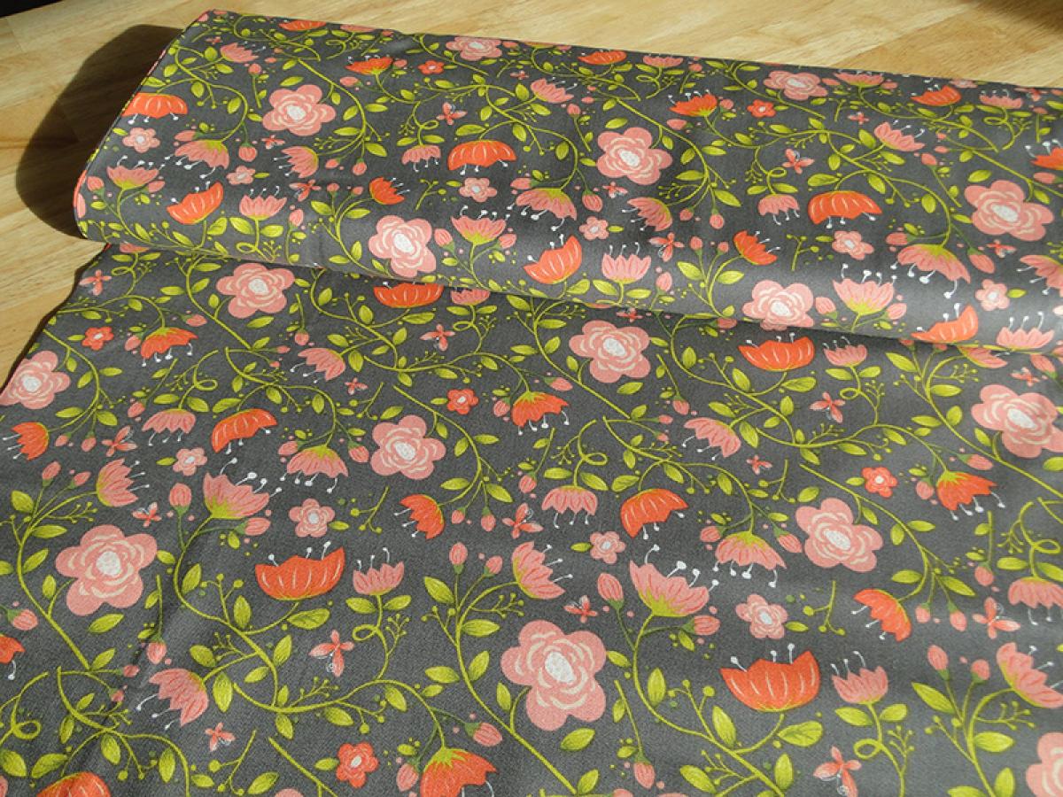 Patchworkstoff, Meterware in grau mit vielen unterschiedlich großen Blüten in rot und rosa.