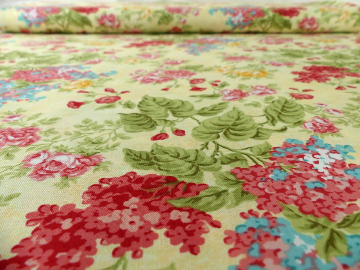 Patchworkstoff. Sommerblumen auf pastellgelbem Hintergrund.