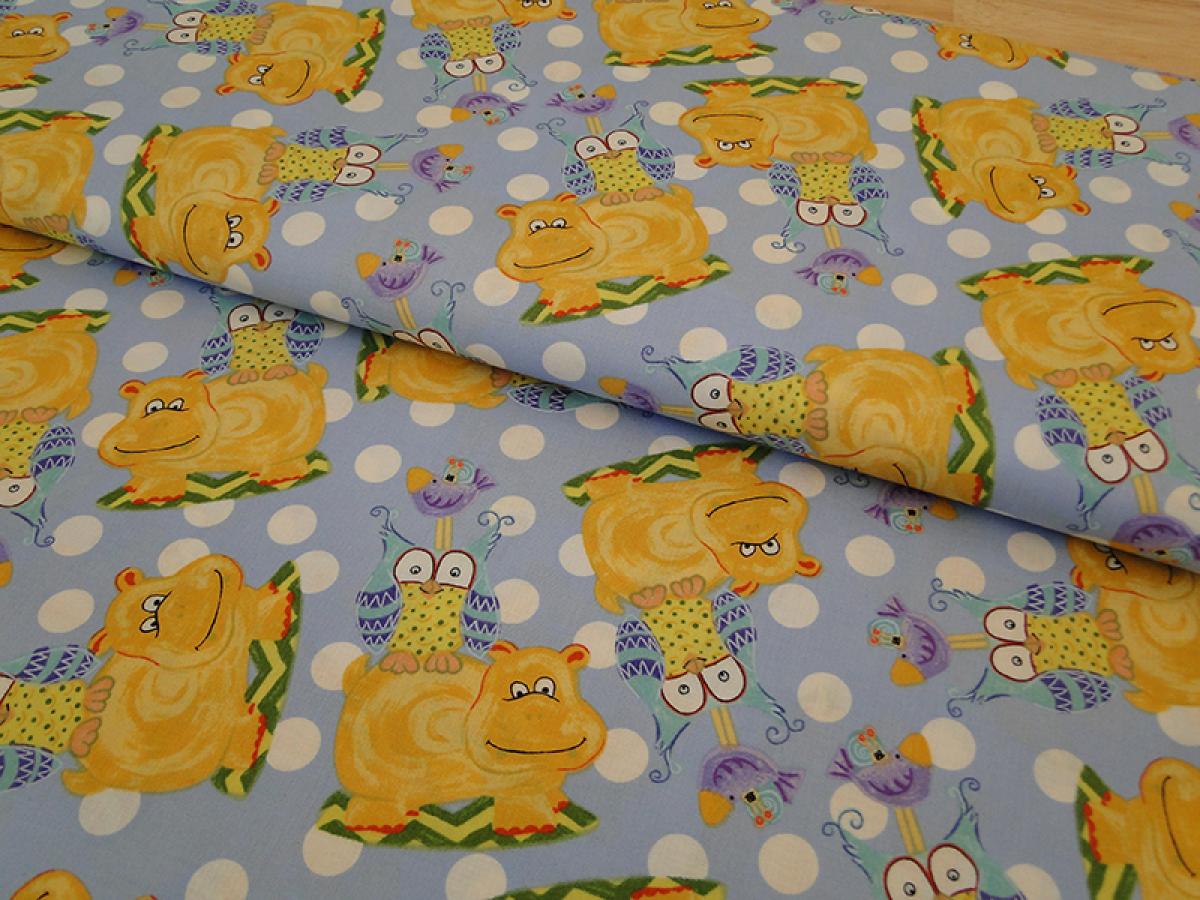 Patchworkstoff mit glücklichen, gelben  Nilpferden und Eulen auf hellblau. Von Extraordinary.