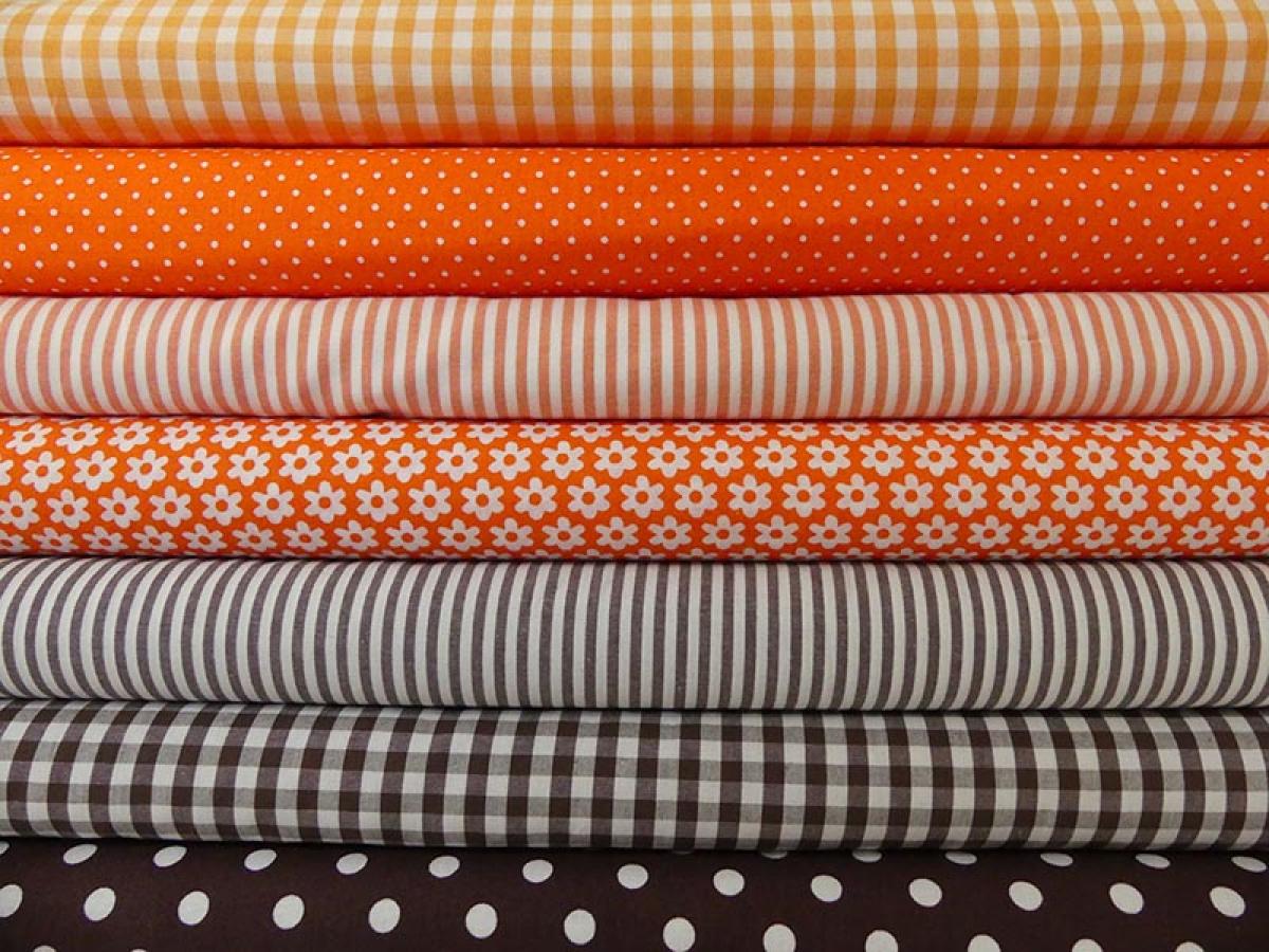 Verschiedene Baumwollstoffe in orange und braun.